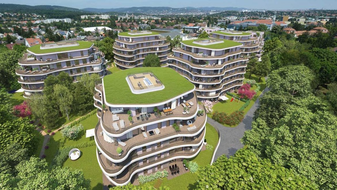 Visualisation: aerial view of five buildings with balconies, grass roofs and curved facing elements in the midst of a densely wooded park